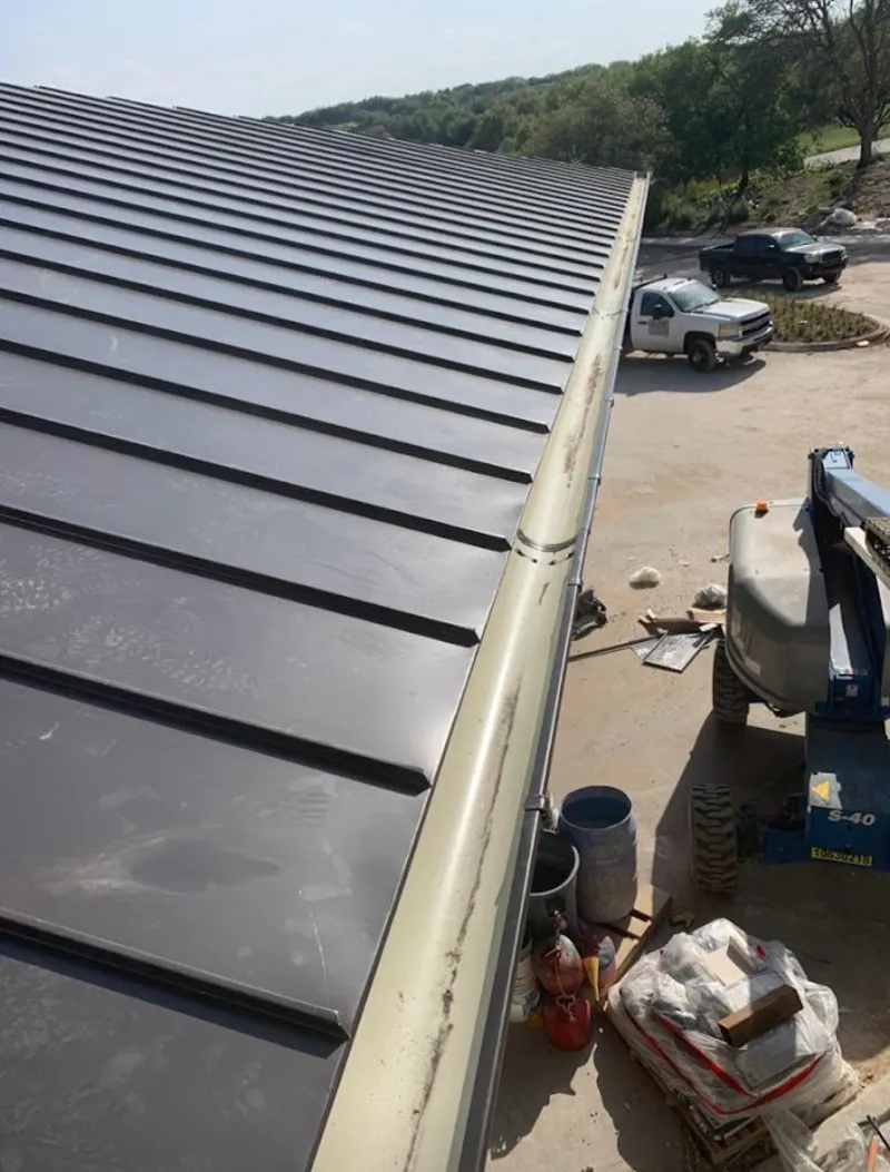 Standing seam panel and gutter detail on a metal roofing jobsite in Seminole
